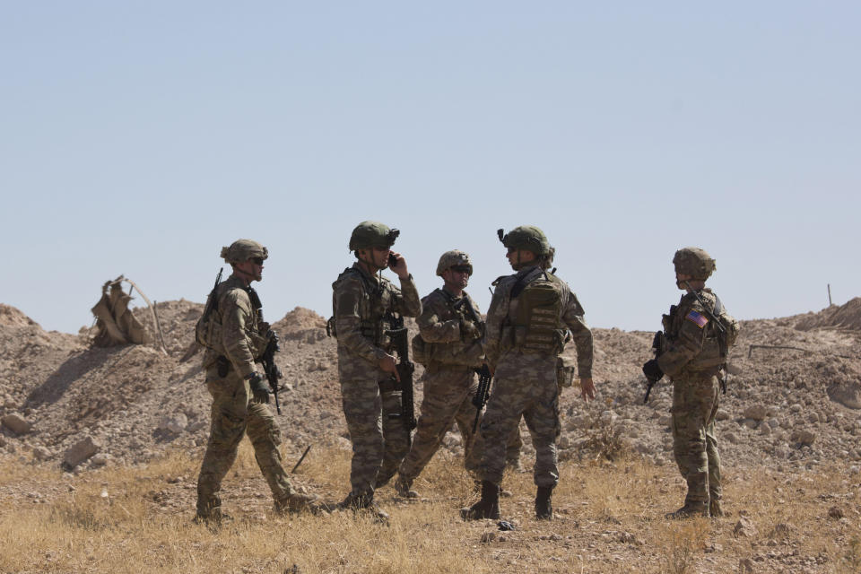 FILE - This Sept. 8, 2019 file photo, Turkish forces survey the so-called safe zone during their first joint ground patrol with U.S. forces on the Syrian side of the border with Turkey, near Tal Abyad, Syria. The region of northeastern Syria, where the Turkish president intends to launch an operation to carve out a safe zone, is one of the most combustible in Syria’s long-running civil war. A U.S. troop withdrawal and Turkish assault on the area risks re-igniting fighting in a corner of Syria only recently stabilized and where sleeper cells of the Islamic State group continue to operate. (AP Photo/Maya Alleruzzo, File)