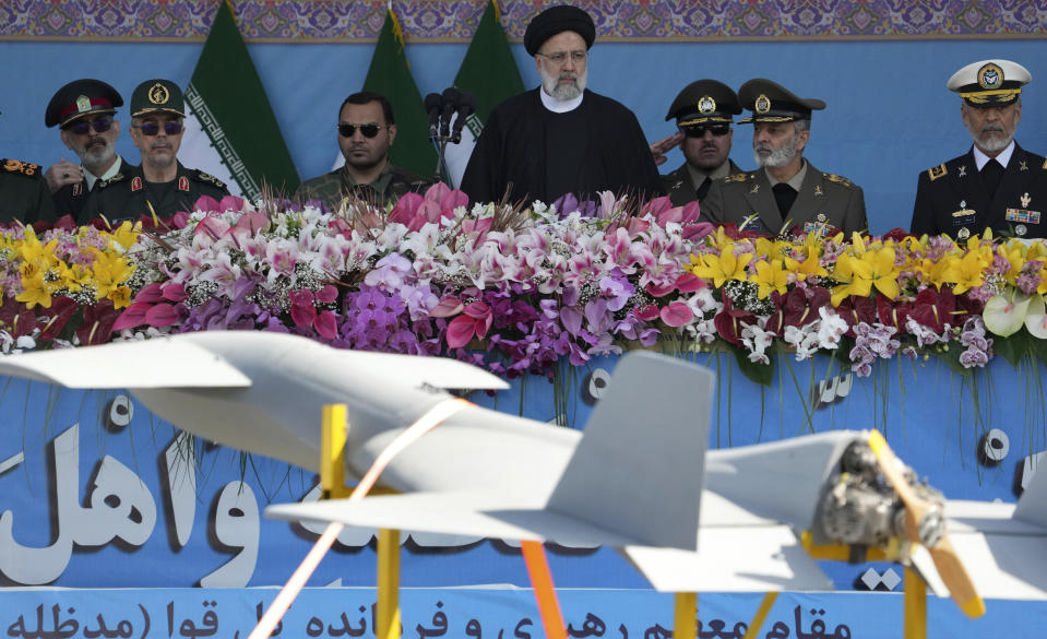 Iranian President Ebrahim Raisi, center, reviews an army parade commemorating Army Day as he is accompanied by the armed forces commanders while a drone is carried on a truck in front of the mausoleum of the late revolutionary founder Ayatollah Khomeini just outside Tehran, Iran, Tuesday, April 18, 2023. President Raisi reiterated threats against Israel while though he stayed away from criticizing Saudi Arabia as Tehran seeks a détente with the kingdom. (AP Photo/Vahid Salemi)