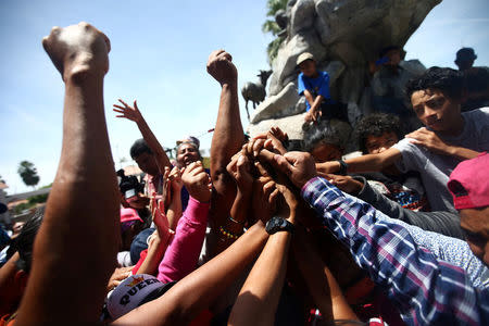 Central American migrants, moving in a caravan through Mexico, join their hands during a demonstration against the U.S President Donald Trump's immigration policies, in Hermosillo, Sonora state, Mexico April 23, 2018. REUTERS/Edgard Garrido