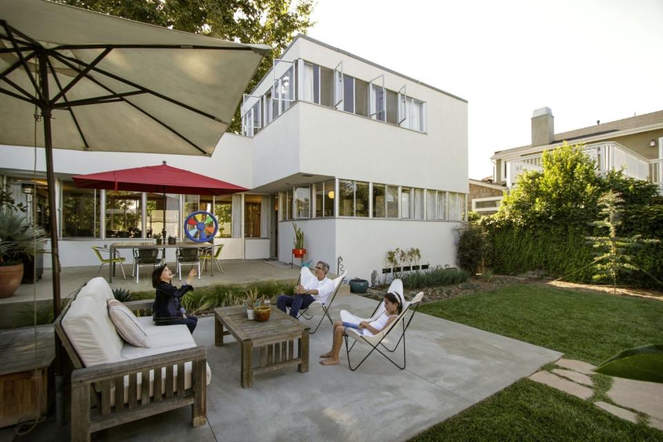 Umbrellas provide shade outside a home designed by Raphael Soriano.