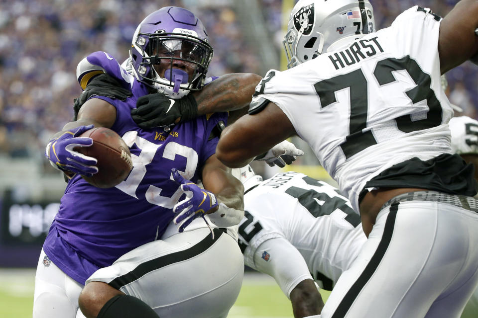 Minnesota Vikings running back Dalvin Cook (33) scores on a 1-yard touchdown run ahead of Oakland Raiders defensive tackle Maurice Hurst (73) during the first half of an NFL football game, Sunday, Sept. 22, 2019, in Minneapolis. (AP Photo/Bruce Kluckhohn)