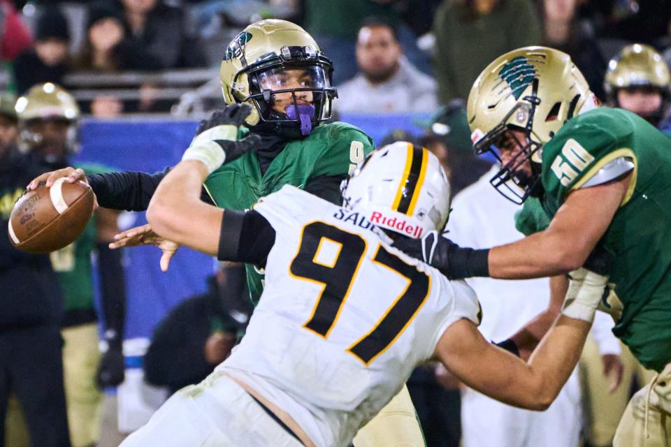 Basha Bears quarterback Demond Williams Jr. (9) makes a pass as Saguaro Sabercats defensive lineman Garrett Martin (97) closes in for a tackle during the Open Division state championship game at Sun Devil Stadium in Tempe on Saturday, Dec. 10, 2022.