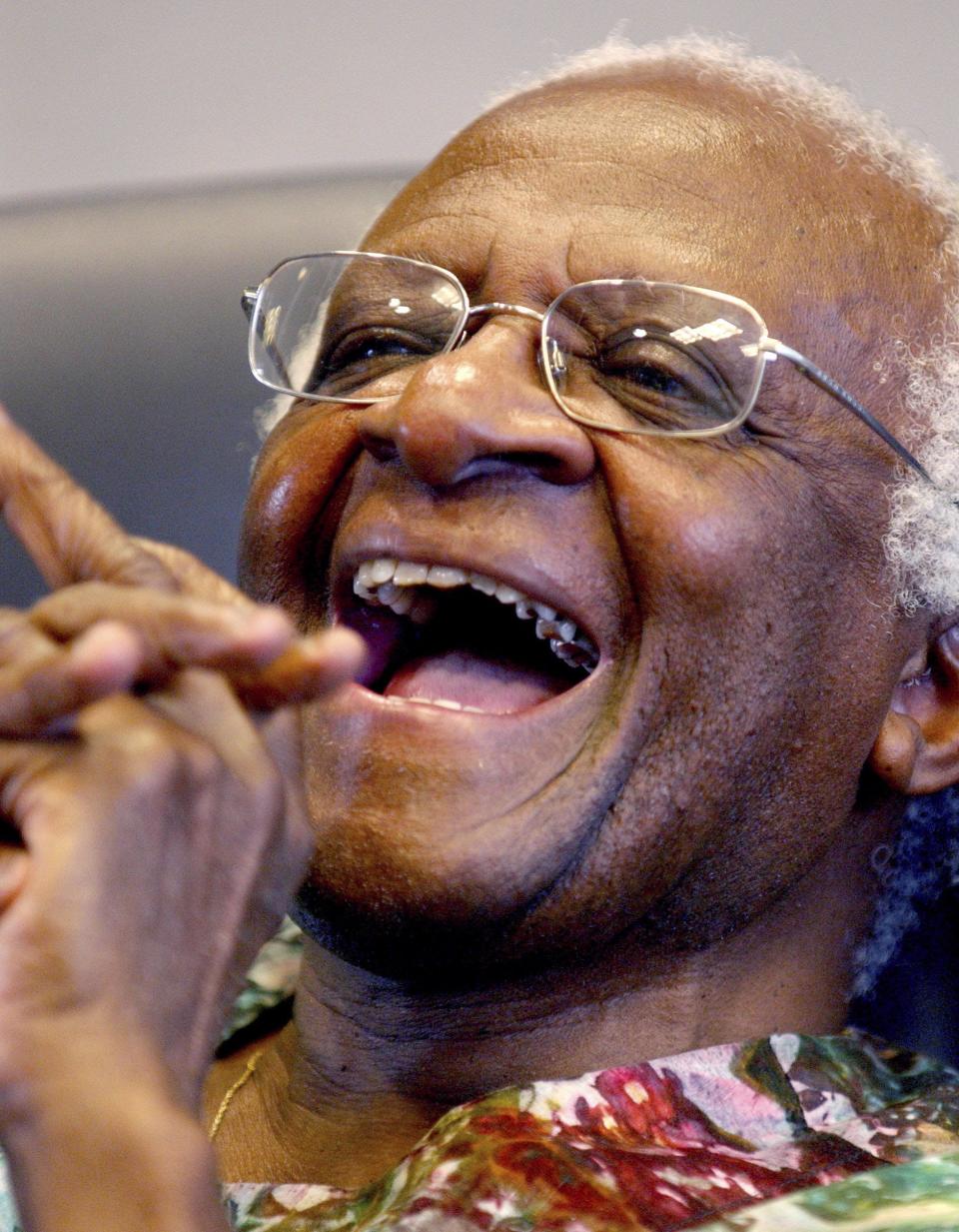 The late Archbishop Desmond Tutu laughs after answering a question about local reaction to his speech at a peace rally in Jacksonville in 2003. Tutu spent a semester as a visiting scholar at the University of North Florida.