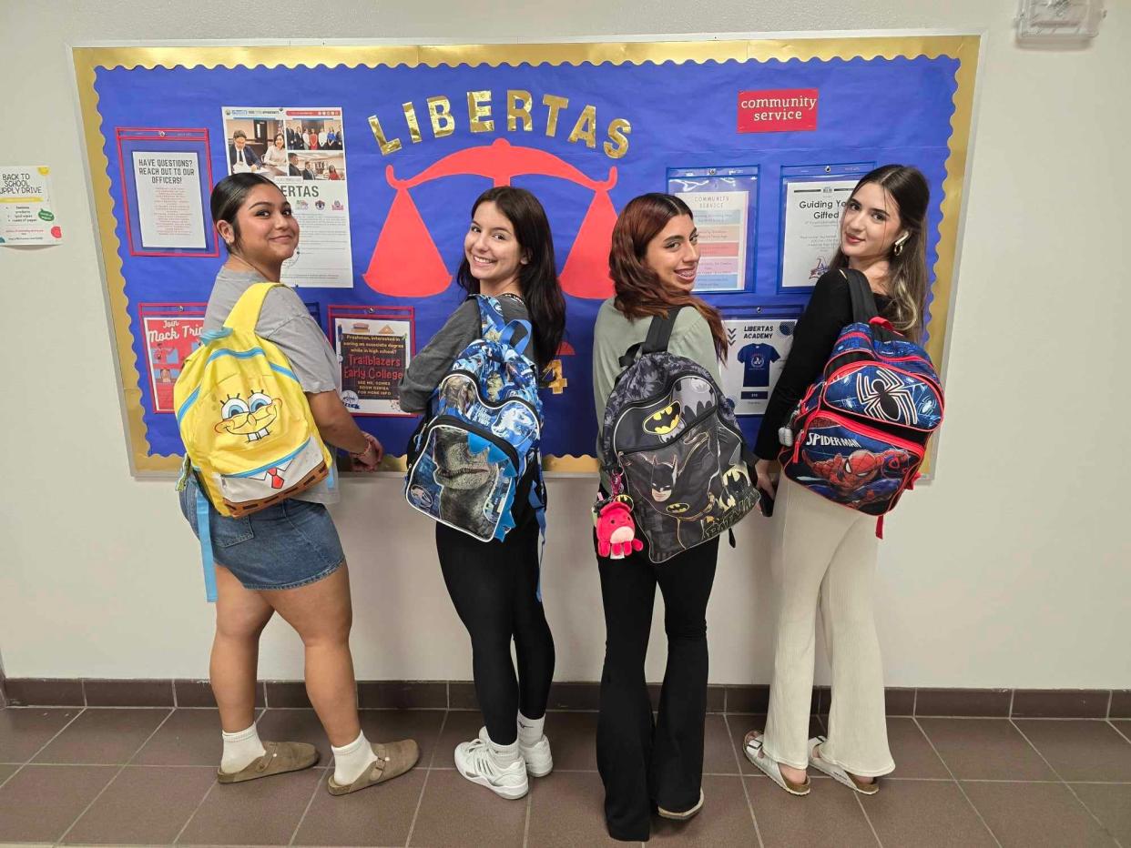 Americas High School students Mia Campos, left, Miliani Reza, Alondra Hernandez-Aguilar, and Jocelyn Cortez, are happy to join in a national trend, toting kiddie-themed backpacks for their final year.