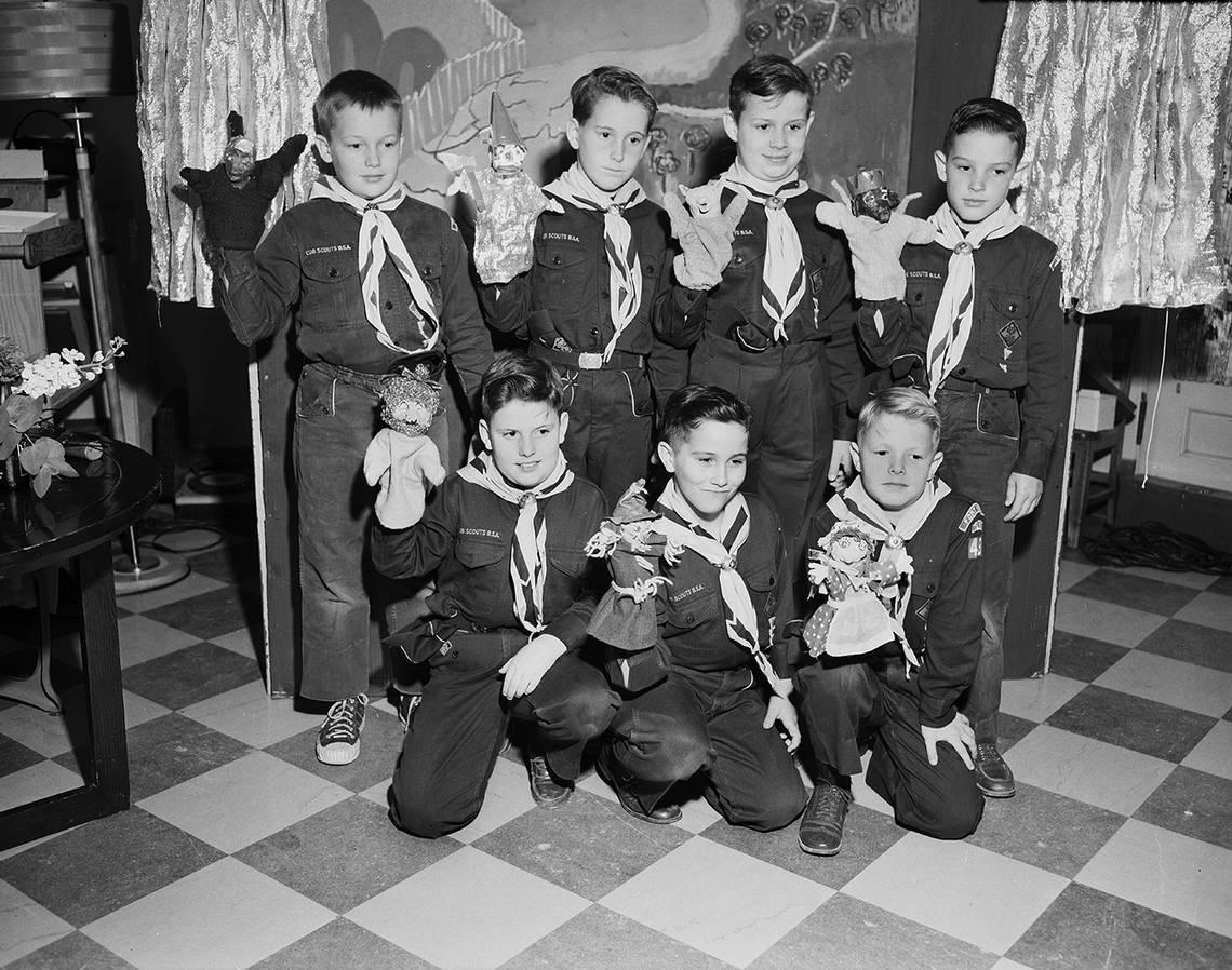 March 19, 1954: Members of Cub Scout Den 1, Pack 49, Horned Frog District of the Longhorn Council of Boy Scouts, display puppets made for a skit presented to children at W.I. Cook Memorial Hospital Center for Children. They are, left to right, front row, Michael Smith, Kenneth Herburger and Pete Gray; back row, Burton Tims, Taber Chamberlain, Arthur Weinman and Ronald Greer. Fort Worth Star-Telegram archive/UT Arlington Special Collections