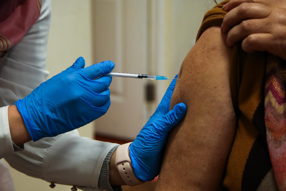 A NHS vaccinator, administers the Pfizer/BioNTech Covid-19 booster vaccine to a woman at a vaccination centre. (Photo by Dinendra Haria / SOPA Images/Sipa USA)