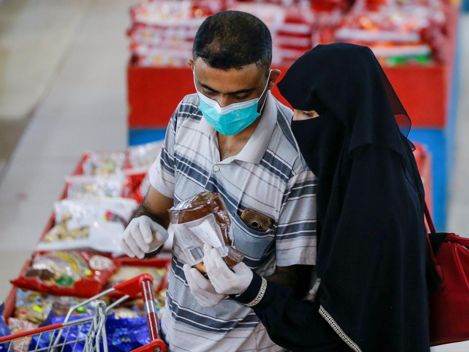 FILE PHOTO: A couple wearing protective face masks and gloves shop at a supermarket amid concerns of the spread of the coronavirus disease (COVID-19), in Sanaa, Yemen May 11, 2020. REUTERS/Khaled Abdullah/