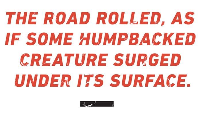 Text: The road rolled, as if some humpbacked creature surged under its surface