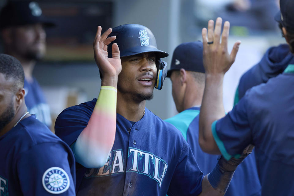 Seattle Mariners' Julio Rodriguez is greeted in the dugout after scoring on a sacrifice hit by Abraham Toro against the Oakland Athletics during first inning of a baseball game, Thursday, June 30, 2022, in Seattle. (AP Photo/John Froschauer)