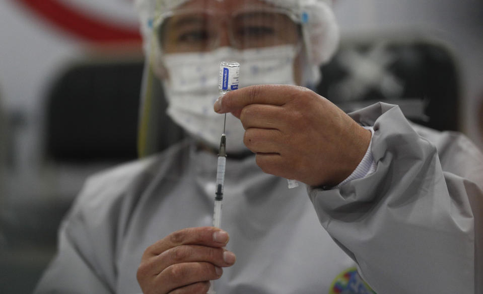 A healthcare worker prepares a dose of Russia's Sputnik V COVID-19 vaccine, at the Del Norte Hospital in El Alto, Bolivia, Saturday, Jan. 30, 2021. (AP Photo/Juan Karita)