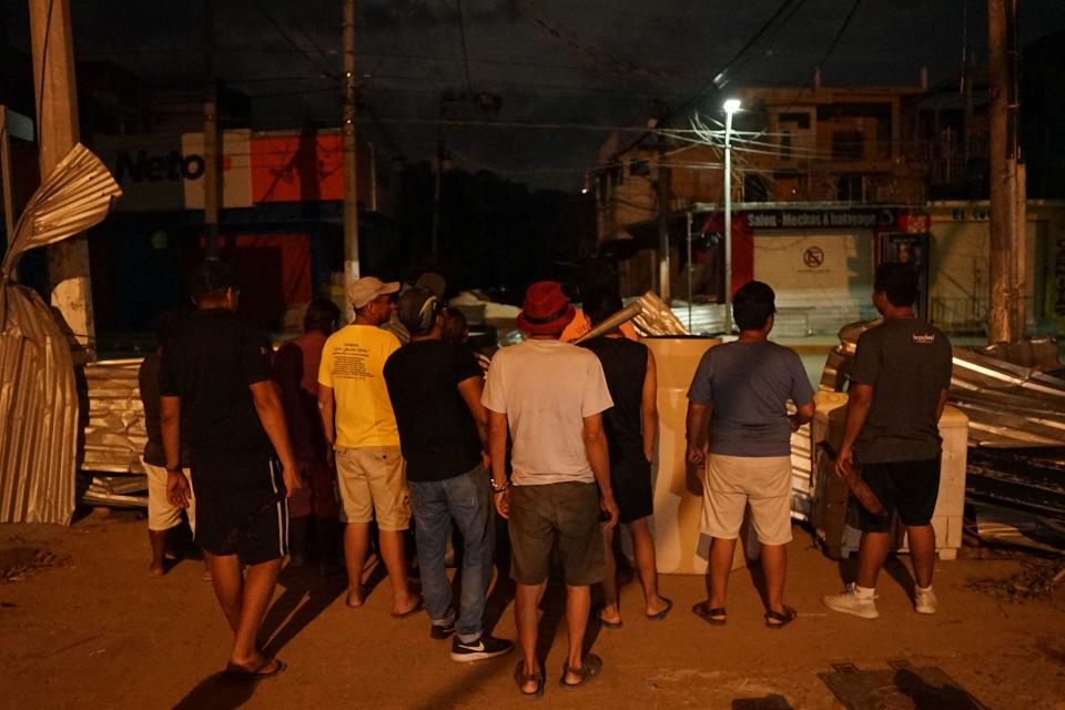 Los residentes del barrio Progreso resguardan una calle como medida de seguridad tras los saqueos y la inseguridad que siguieron al paso del huracán Otis por Acapulco, estado de Guerrero, México, el 30 de octubre de 2023. Otis azotó la ciudad portuaria temprano el 25 de octubre con vientos de 270 kilómetros por hora, dejando un rastro de destrucción. La tormenta dañó gravemente o destruyó numerosos edificios y provocó cortes de energía y comunicaciones. Las estanterías de los supermercados quedaron rápidamente vacías en una ola de saqueos. (Foto de SILVANA FLORES / AFP) (Foto de SILVANA FLORES / AFP a través de Getty Images)