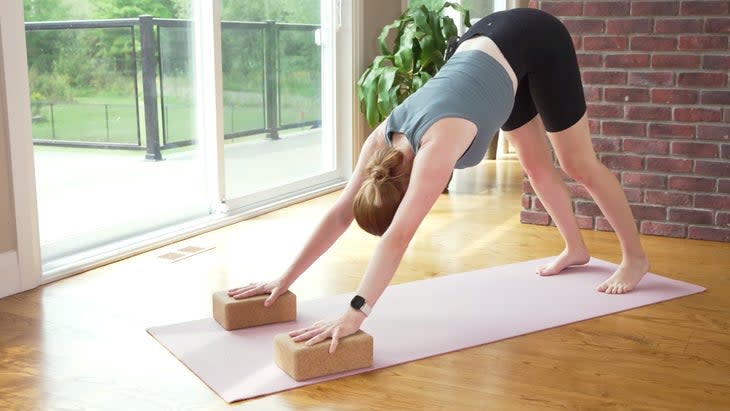 Yoga With Kassandra practicing Downward-Facing Dog during a 20-minute power yoga practice with her hands on blocks.