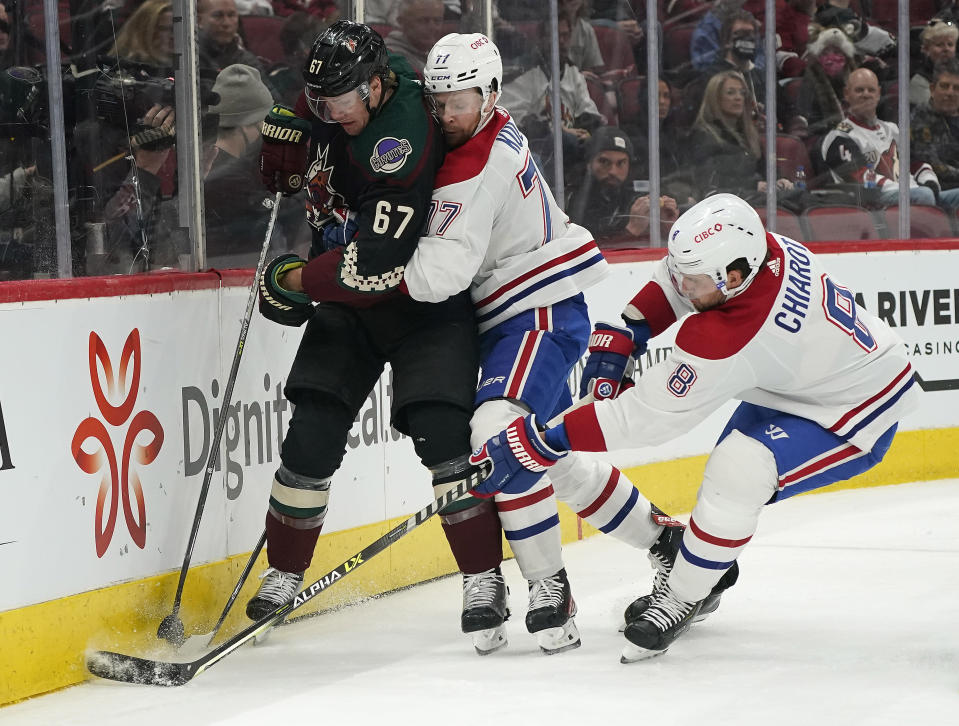 Arizona Coyotes' Lawson Crouse (67) gets double-teamed by Montreal Canadiens' Brett Kulak (77) and Ben Chiarot (8) during the first period of an NHL hockey game Monday, Jan. 17, 2022, in Glendale, Ariz. (AP Photo/Darryl Webb)