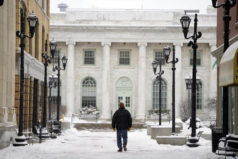 A man walks on the Dunham Mall in Pittsfield, Mass., toward City Hall on Tuesday, Feb. 28, 2023. As much as 7 or 8 inches (18 to 20 centimeters) of snow blanketed some communities in the Northeast by Tuesday morning.(Ben Garver/The Berkshire Eagle via AP)