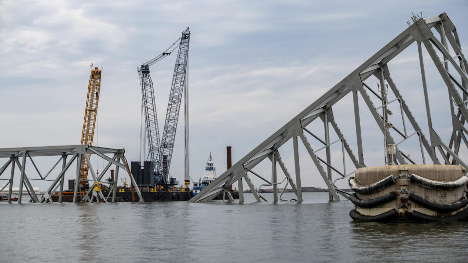 In this photo provided by the U.S. Coast Guard, salvage operations on the Francis Scott Key Bridge take place, Saturday, March 30, 2024, in Baltimore. Salvage teams used an exothermic cutting torch to systematically separate sections of the steel bridge, which will be taken to a disposal site. (Petty Officer 3rd Class Kimberly Reaves/U.S. Coast Guard via AP)