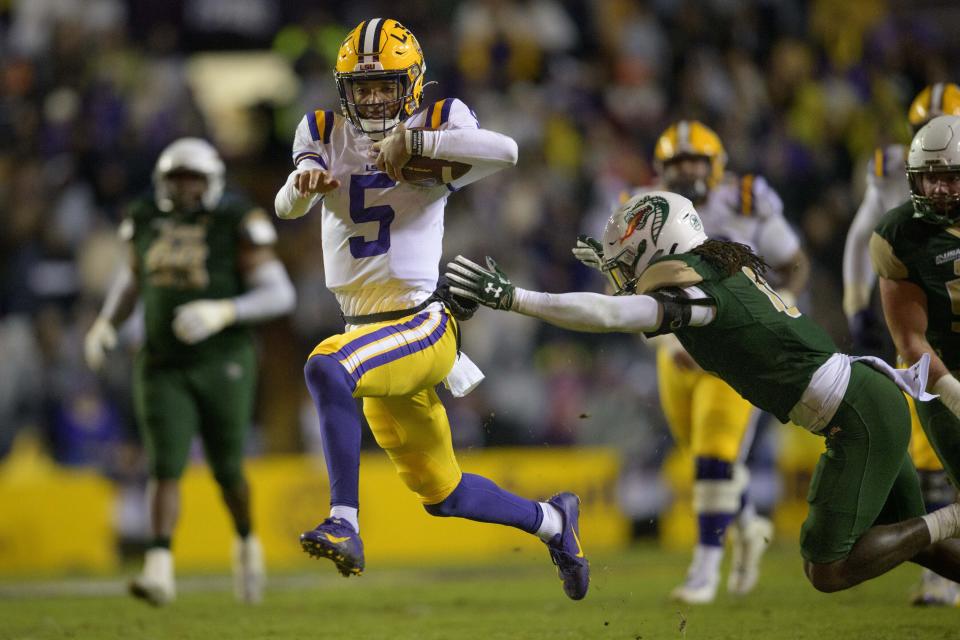 LSU quarterback Jayden Daniels (5) runs past UAB safety Keondre Swoopes (0) during the first half an NCAA college football game in Baton Rouge, La., Saturday, Nov. 19, 2022. (AP Photo/Matthew Hinton)