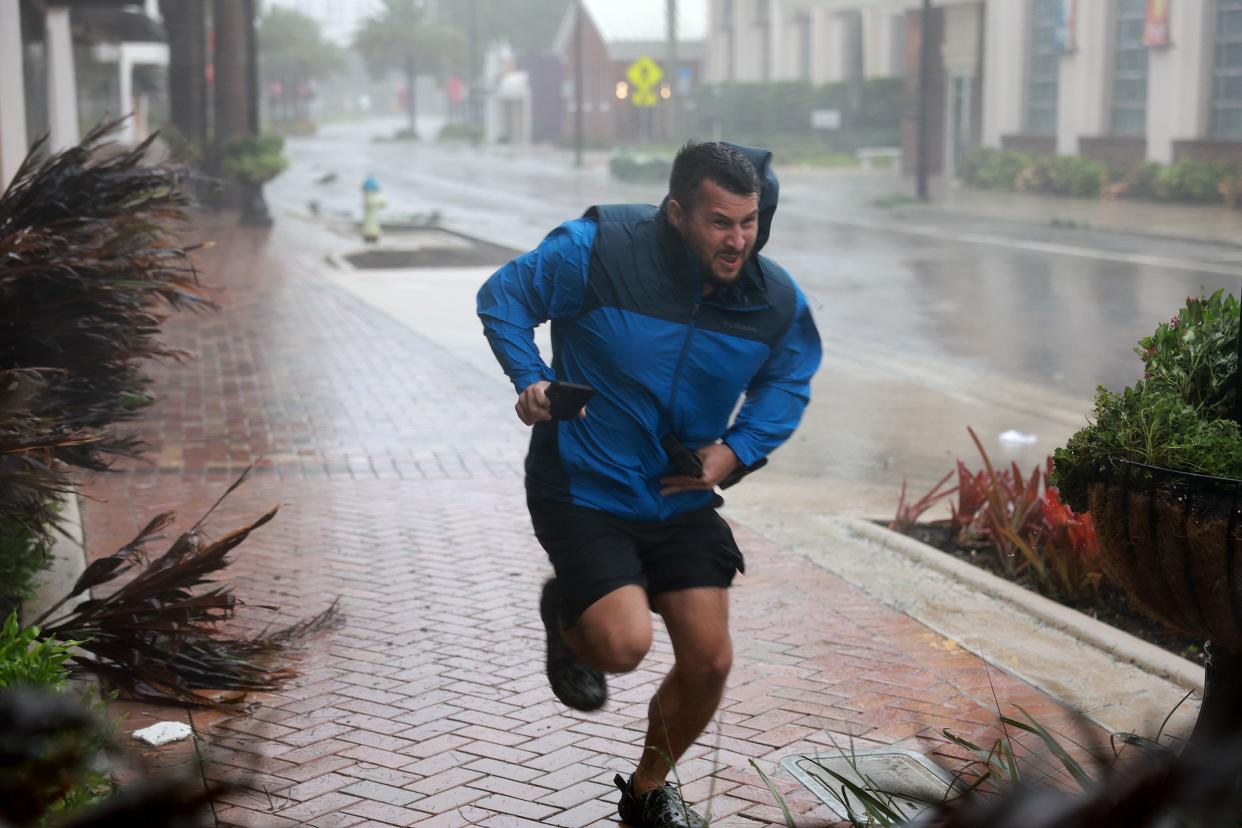 Brent Shaynore runs to a sheltered spot through the wind and rain from Hurricane Ian on Sept. 28, 2022, in Sarasota, Fla. Ian made landfall with 150-mile-per-hour winds and a 12-foot storm surge and knocking out power to nearly 1.5 million customers, according to published reports.