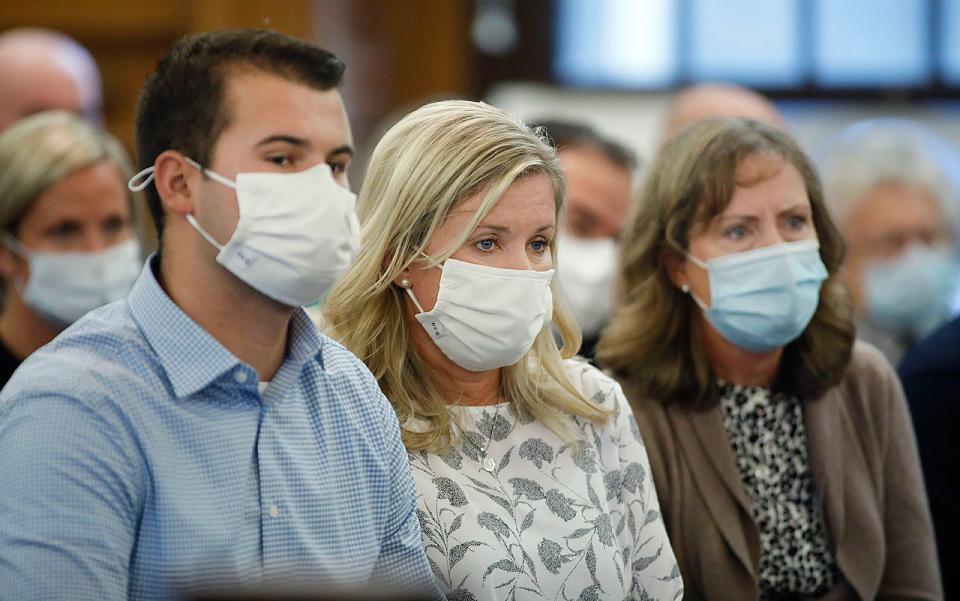 Ryan McCallum, left, Kathy McCallum, center, and sister-in-law Patti Doyle listen to the opening arguments of the manslaughter case in the death of Chris McCallum in Norfolk County Superior Court on Tuesday, Oct. 26, 2021.