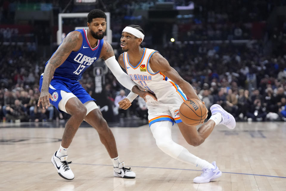 Oklahoma City Thunder guard Shai Gilgeous-Alexander, right, tries to drive past Los Angeles Clippers forward Paul George during the first half of an NBA basketball game Tuesday, Jan. 16, 2024, in Los Angeles. (AP Photo/Mark J. Terrill)