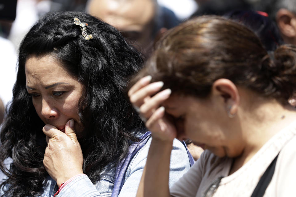 Victims' family members weep during a memorial ceremony in front of the site at Alvaro Obregon 286, where 49 died when their office building collapsed in last year's 7.1 magnitude earthquake, in Mexico City, Wednesday, Sept. 19, 2018. Across the city, memorials were held at sites where hundreds perished in the Sept. 19, 2017 quake.(AP Photo/Rebecca Blackwell)