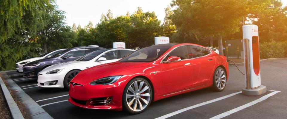 Tesla red Model S at a Supercharger station