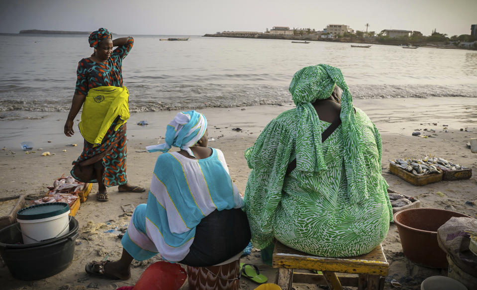 Fishmongers sit after a long day at the Soumbedioune fish market in Dakar, Senegal, May 31, 2022. According to a U.S. report, one in six people work in the fisheries sector. (AP Photo/Grace Ekpu)