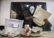 An electoral worker with a mask of the Amon character of the Legend of Korra animated series counts ballots after the second day of the Constitutional Convention election to select assembly members that will draft a new constitution, in Santiago, Chile, Sunday, May 16, 2021. The South American country is choosing 155 people to draft a constitution to replace one that has governed it since being imposed during a military dictatorship. (AP Photo/Esteban Felix)