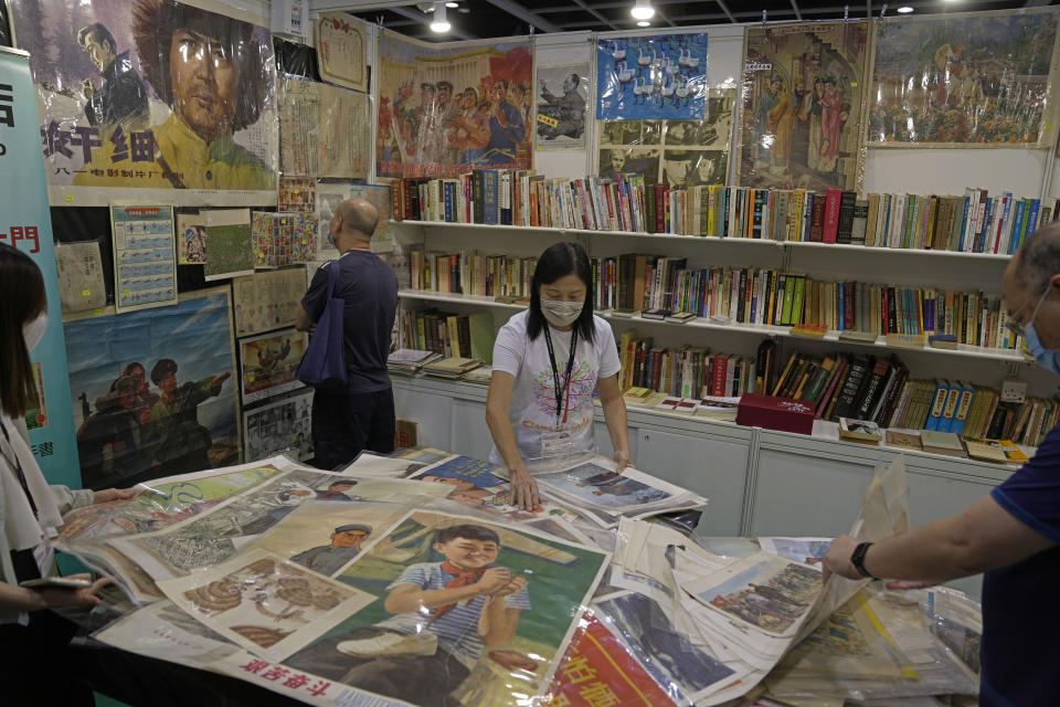 Visitors look at posters at a booth during the annual book fair in Hong Kong, Wednesday, July 20, 2022. The Hong Kong Book Fair will be held on July 20-26. (AP Photo/Kin Cheung)