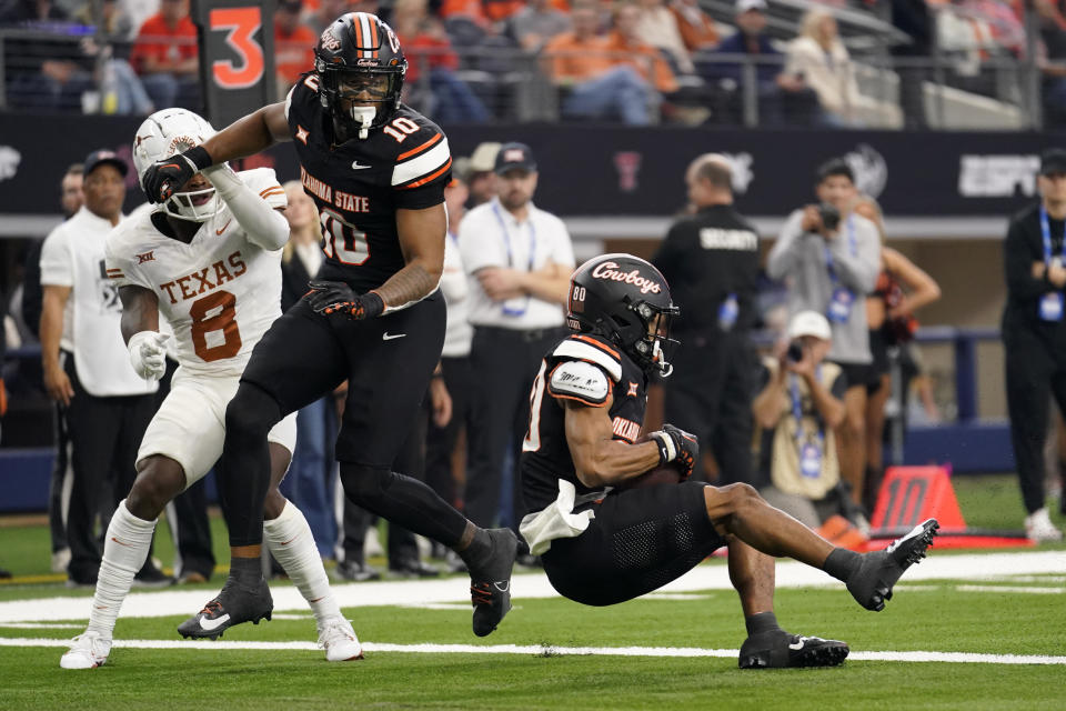 Oklahoma State wide receiver Brennan Presley (80) catches a touchdown pass as as Rashod Owens (10) and Texas defensive back Terrance Brooks (8) look on in the first half of the Big 12 Conference championship NCAA college football game in Arlington, Texas, Saturday, Dec. 2, 2023. (AP Photo/Tony Gutierrez)