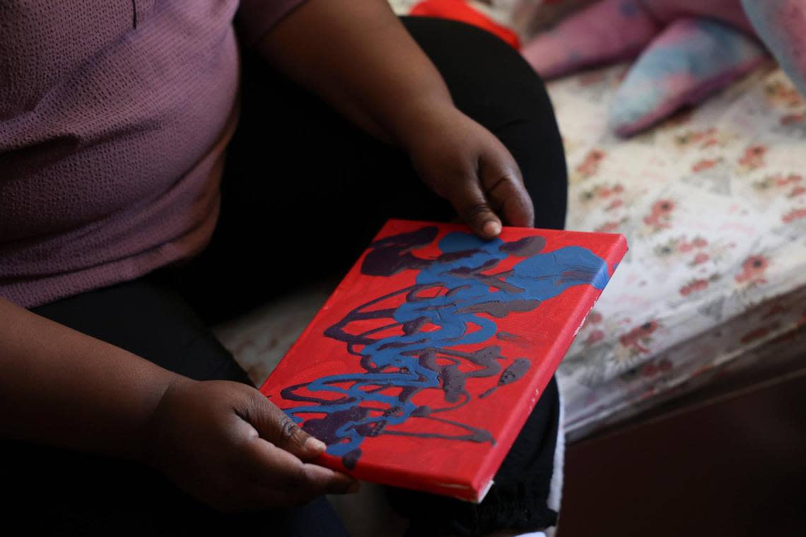 Rachel Jean-Marie holds a painting her daughter Darchelle made for her.