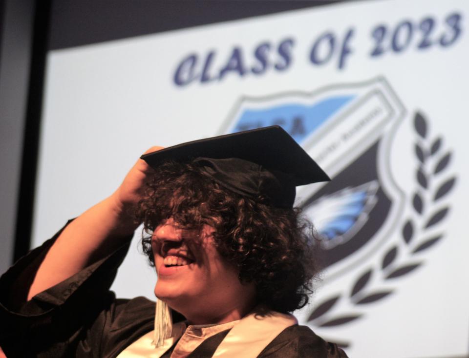 Gabriel Mendoza laughs as he tries to keep his mortar board from falling during Friday's TLCA graduation.