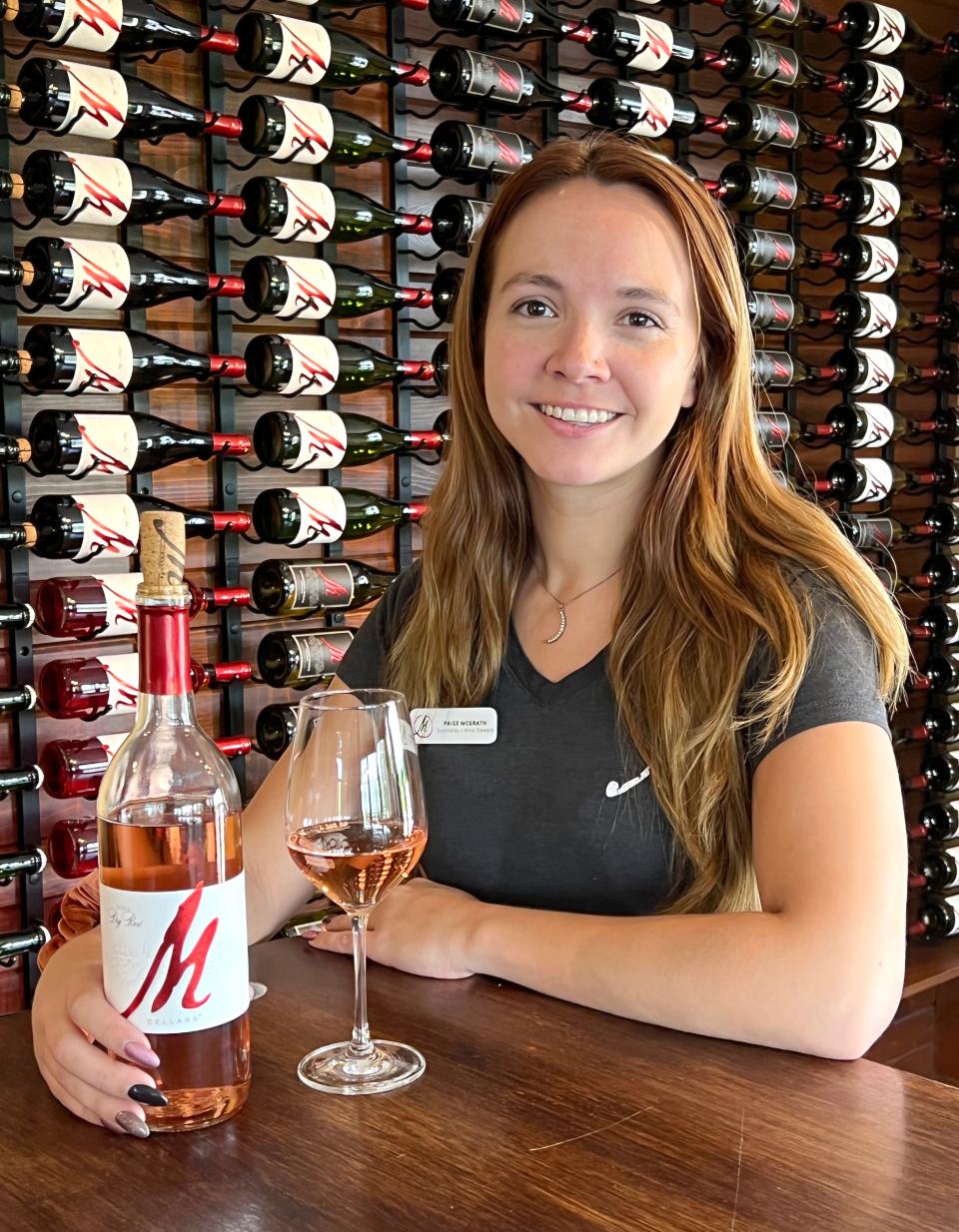 Paige McGrath, who will soon be a Level 3 sommelier at M Cellars in Geneva, holds a bottle of the winery's 2022 dry rosé that was voted best in Ohio at the 2023 Ohio Wine Competition.