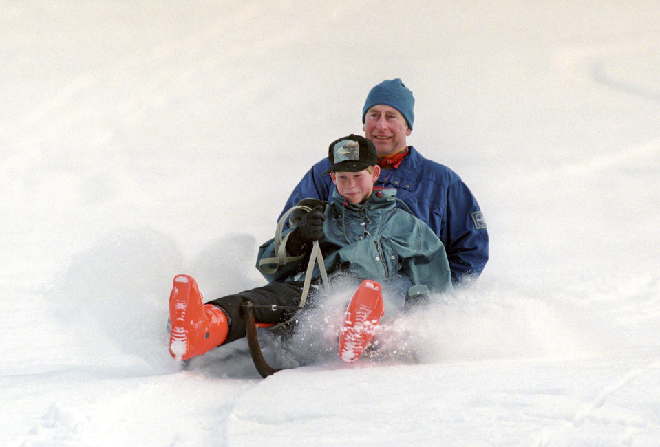 Prince Charles and Prince Harry sledding during a ski holiday in Switzerland. (Julian Parker / UK Press via Getty Images)