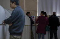 Investors chat with each others as they monitor stock prices at a brokerage house in Beijing, Wednesday, Oct. 23, 2019. Asian stock markets followed Wall Street lower Wednesday after major companies reported mixed earnings and an EU leader said he would recommend the trade bloc allow Britain to delay its departure. (AP Photo/Andy Wong)