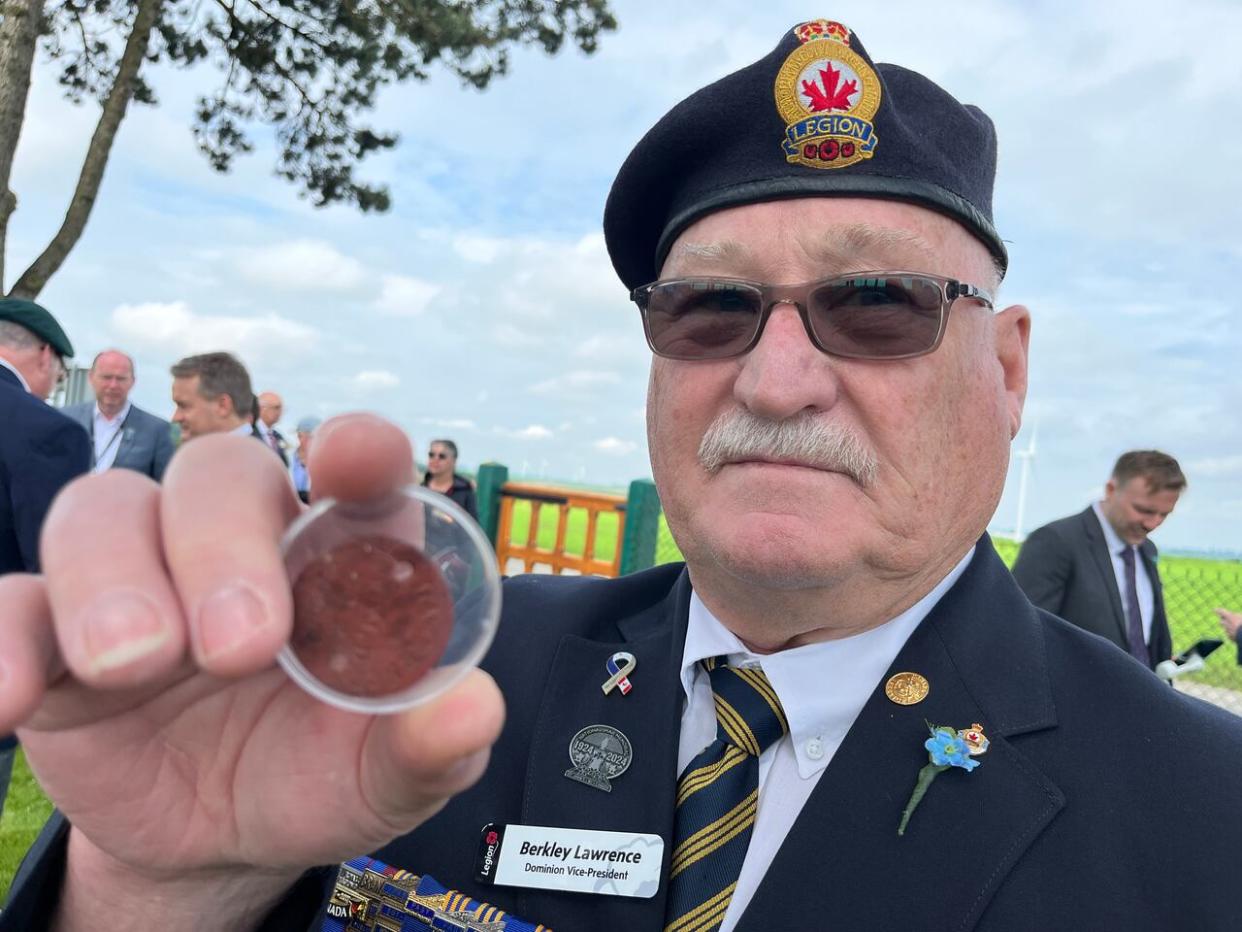 Berkley Lawrence of Carbonear will become national president of the Royal Canadian Legion this summer, and along with other legionnaires such as Frank Sullivan and Gary Browne, are playing a pivotal role in the repatriation of an unknown Royal Newfoundland Regiment soldier from northern France this week. Lawrence is pictured here holding a First World War identity disc that belonged to his grandfather, Stephen Lawrence, who was wounded at both Beaumont-Hamel and Gueudecourt. (Terry Roberts/CBC - image credit)