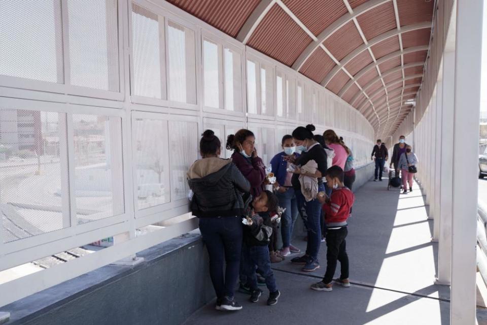 A group of migrants rapidly deported from the US under Title 42 wait on the Mexican side of the Paso del Norte International Bridge, between El Paso, Texas and Ciudad Juarez, Mexico on March 10, 2021. - Title 42 was implemented during the pandemic as a means of reducing the spread of Covid-19, rapidly expelling migrants that crossed illegally via international ports of entry on the US-Mexico border. (Photo by Paul Ratje / AFP) (Photo by PAUL RATJE/AFP via Getty Images)