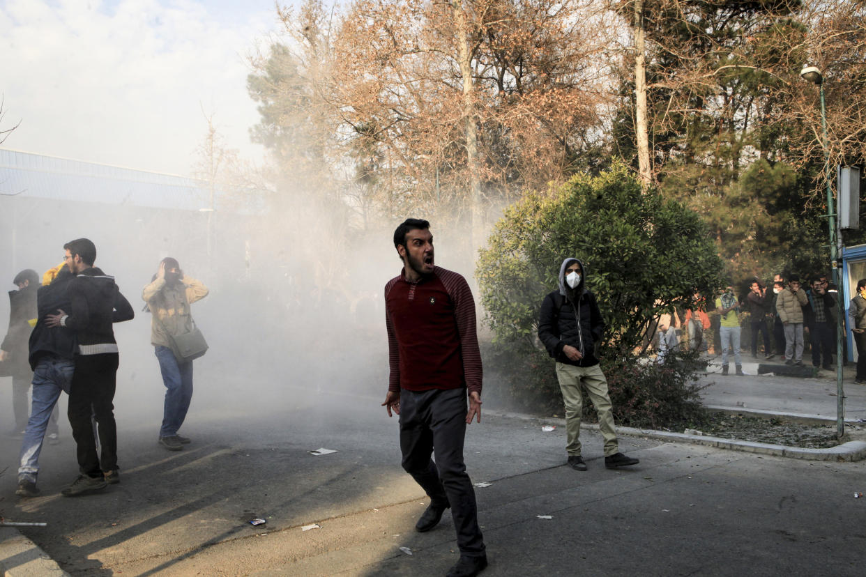 Das Foto vom 30.12.2017 von einem nicht bei AP beschäftigten Fotografen, das der AP außerhalb des Irans zur Verfügung gestellt wurde, zeigt Studenten der Universität in Teheran (Iran) bei einer Demonstration, im Hintergrund steigt der Rauch einer Tränengasgranate der Polizei auf.