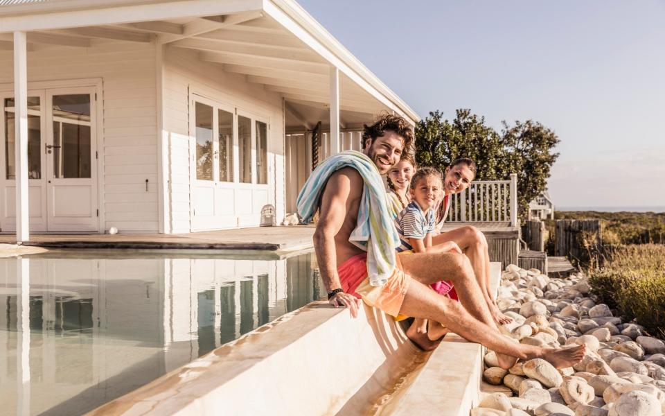 Young european family enjoying the sunset and having fun at beach house