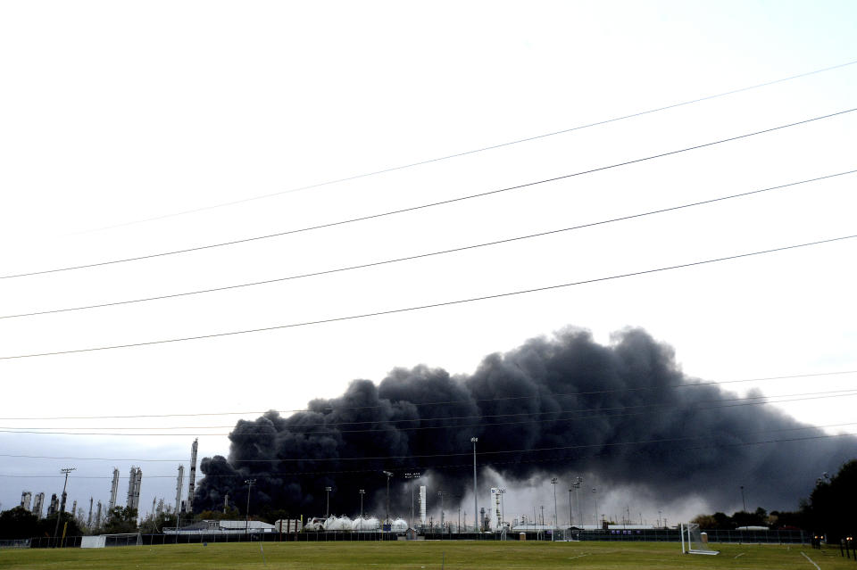 Thick smoke fills the sky above the TPC Group Port Neches Operations as emergency response crews try to contain the fire that continued to burn throughout the morning following an overnight explosion on Wednesday, Nov. 27, 2019, in Port Neches, Texas. Three workers were injured early Wednesday in a massive explosion at the Texas chemical plant that also blew out the windows and doors of nearby homes. (Kim Brent/The Beaumont Enterprise via AP)