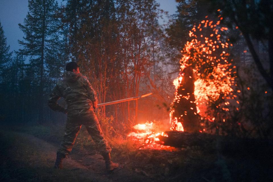 A member of volunteers crew mops up spot fires at Gorny Ulus area west of Yakutsk, Russia, Thursday, July 22, 2021. The hardest hit area is the Sakha Republic, also known as Yakutia, in the far northeast of Russia, about 5,000 kilometers (3,200 miles) from Moscow. About 85% of all of Russia's fires are in the republic, and heavy smoke forced a temporary closure of the airport in the regional capital of Yakutsk, a city of about 280,000 people. (AP Photo/Ivan Nikiforov)