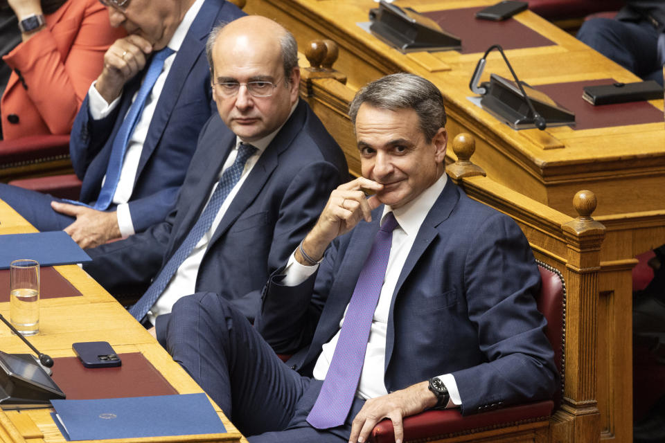 Greece's Prime Minister Kyriakos Mitsotakis, right, and National Economy and Finance Minister Kostis Hatzidakis attend a parliament session in Athens, Greece, Saturday, July 8, 2023. The newly elected Greek government seeks a vote of confidence from the parliament, following a three-day debate. (AP Photo/Yorgos Karahalis)