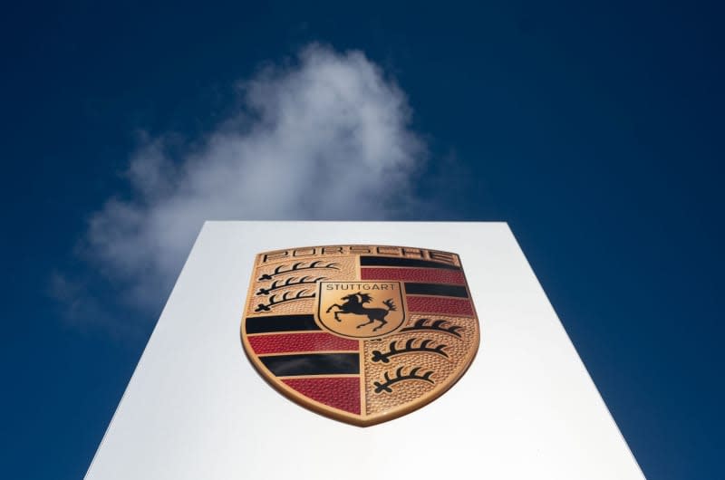 The Porsche AG logo can be seen against a slightly cloudy sky. Marijan Murat/dpa