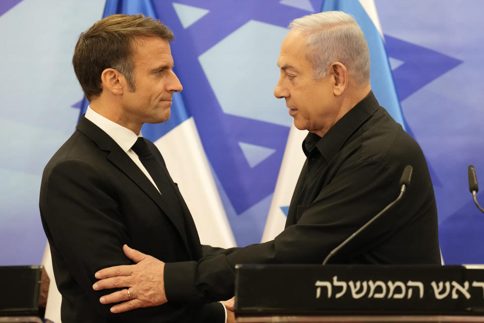 Israeli Prime Minister Benjamin Netanyahu, right, shakes hands with French President Emmanuel Macron after a joint press conference in Jerusalem, Tuesday, Oct. 24, 2023. Emmanuel Macron is traveling to Israel to show France's solidarity with the country and further work on the release of hostages who are being held in Gaza. (AP Photo/Christophe Ena, Pool)
