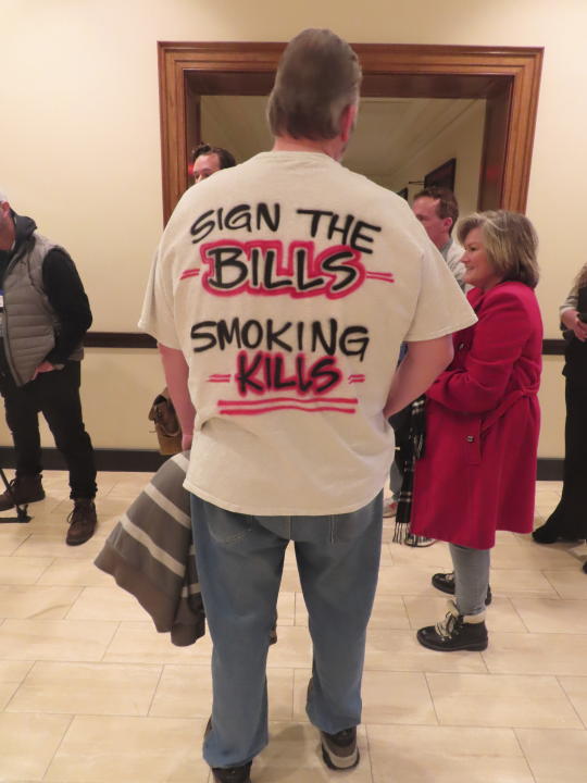 A man wears a T-shirt supporting a casino smoking ban to a hearing at which a New Jersey Senate committee advanced a bill that would ban smoking in Atlantic City's nine casinos, Monday, Jan. 29, 2024, in Trenton, N.J. The bill still needs numerous additional votes before becoming law. (AP Photo/Wayne Parry)