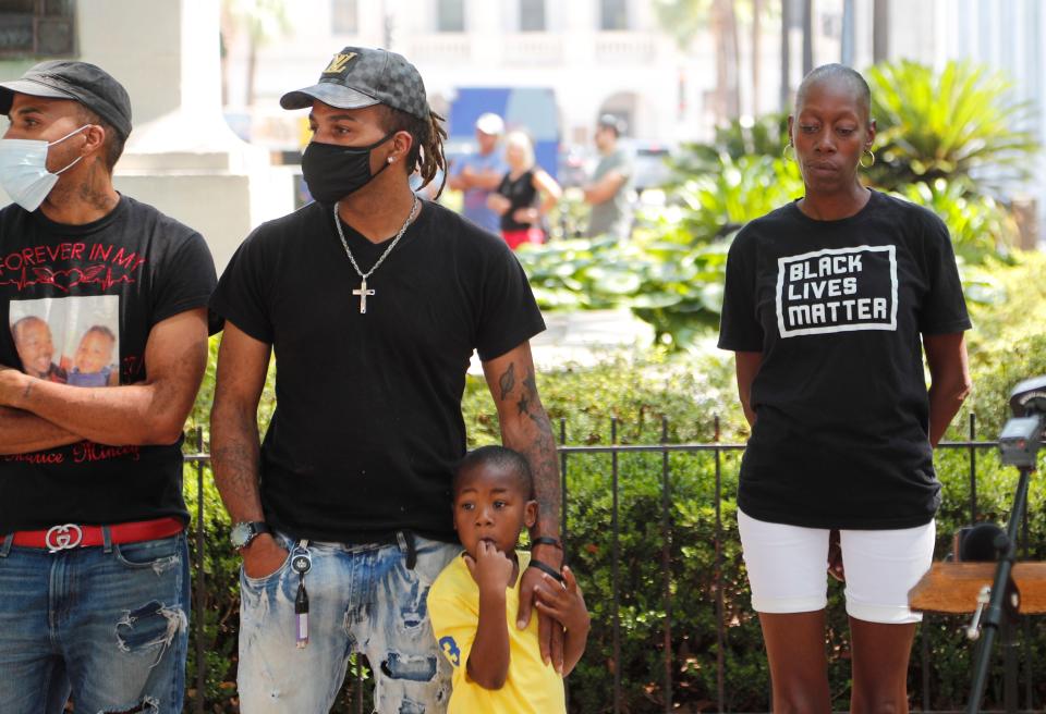 Maria Scott, right, stands with her son and fiancé's brothers Domonique Mincey (center) and Marque Jerido before the start of a press conference to address the recent announcement by the Chatham County District Attorney in regards to the Savannah Police shooting of her fiancé Maurice Mincey.