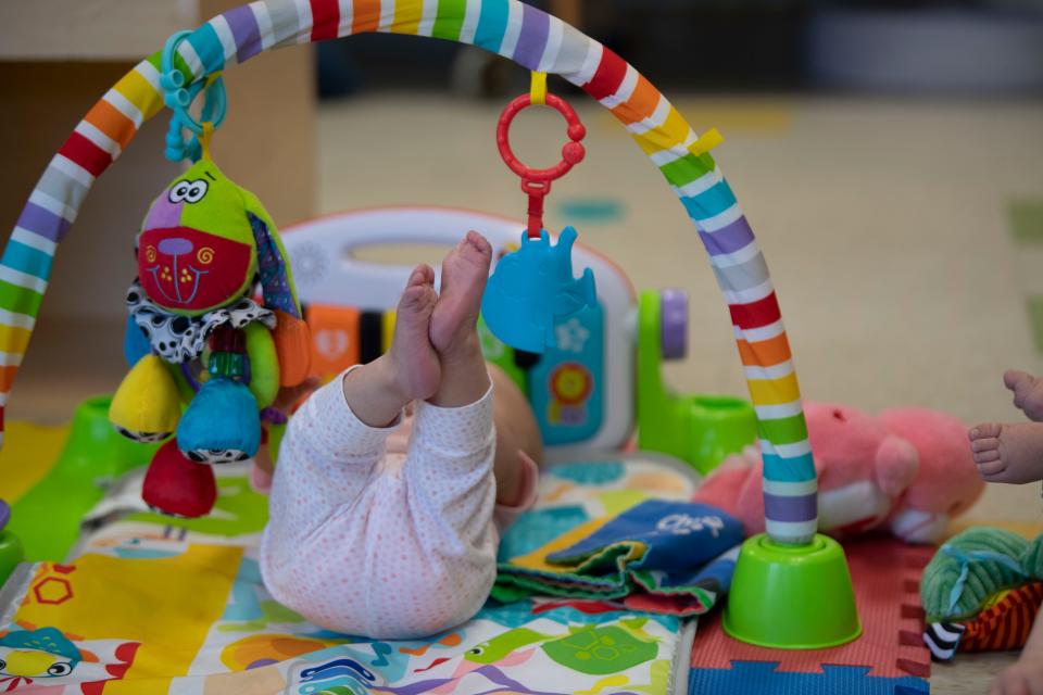 A baby plays with small toys inside the nursery at St. Mary Villa Child Development Center in Nashville, Tenn., Monday, Sept. 25, 2023.