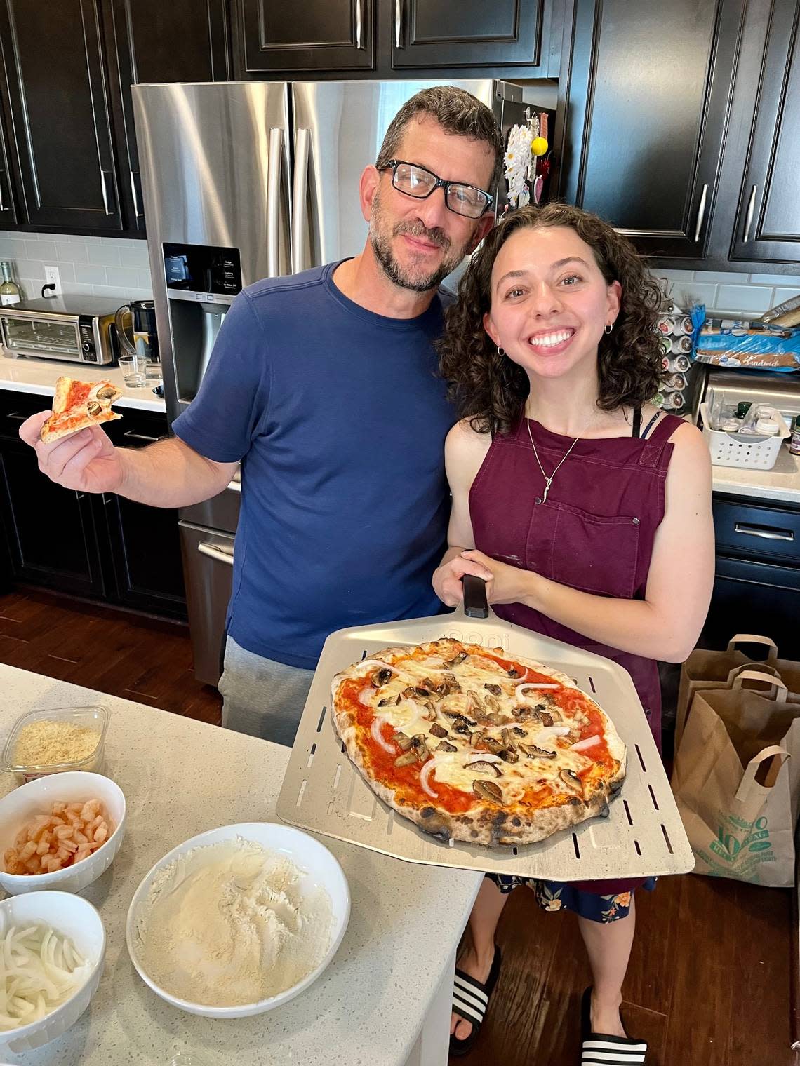 Reporter Kimberly Cataudella and her dad, Carmelo, with a pizza they made at their home in the Triangle.