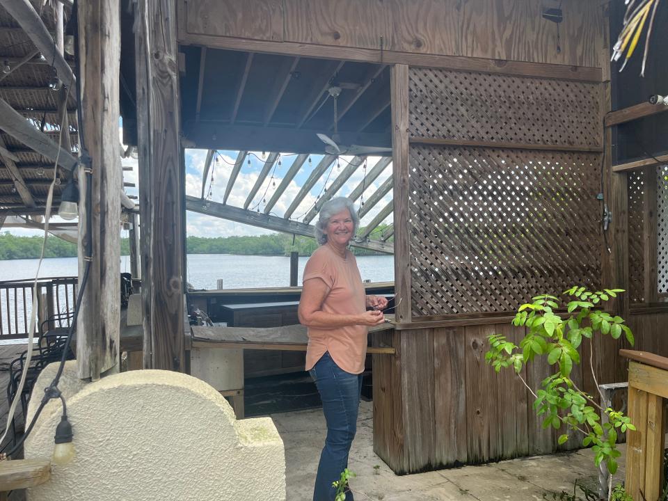Glenda Hancock, a lifetime resident of Everglades City and Chokoloskee, stands on the dilapidated deck of the old Railroad Depot in Everglades City on Sept. 1, 2023. She has been helping the building's owner in trying to save it.