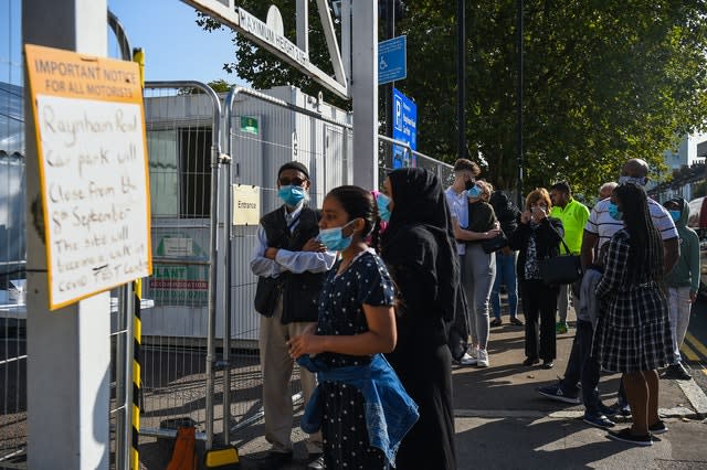 People queue outside a coronavirus testing centre offering walk-in appointments in north London