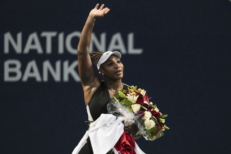 Serena Williams, of the United States, leaves the court carrying flowers and waving to fans after her loss to Belinda Bencic, of Switzerland, during the National Bank Open tennis tournament Wednesday, Aug. 10, 2022, in Toronto. (Chris Young/The Canadian Press via AP)